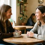 Deux femmes adultes se rencontrent dans un café accueillant de Guéret et discutent chaleureusement autour d’un café.